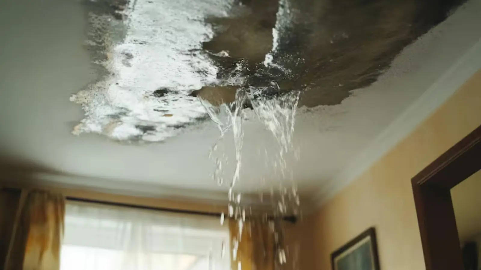 Water running from a stained ceiling in a living room